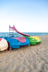 Pedal boats in the beach. Colorful plastic pedal boats to rent.