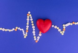 Heart of cardiograms  from color pills on a blue background. Concept of heart disease.