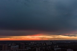 Dramatic sunset cloudscape view in city residential district. Aerial Kharkiv, Ukraine. Evening sky, cloudscape and street lights