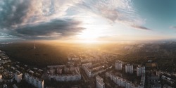 Epic sunrise super wide panorama view in city residential district. Aerial Pavlovo Pole, Kharkiv, Ukraine. Morning skyscape, cloudscape and streets