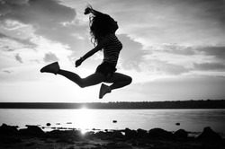 Black and white photography of dance and jump, silhouette outdoors background. Dawn sky