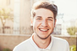 Handsome man outdoors portrait. Man smiling, looking in the camera