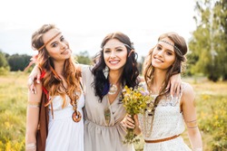 Three beautiful cheerful hippie girls, best friends, the outdoors, trendy hairstyles, feathers in her hair, white dress, tattoo flash, gold accessories, Bohemian, bo-ho style blonde, brunette, redhead