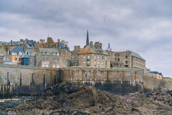 Panoramic view of walled city Saint-Malo in a sunny winter morning and the beach, famous port city of Privateers is known as city corsaire, Brittany, France