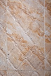 Wet brown marble textured tiles in the bathroom. 