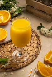 Orange juice cocktail with fresh orange fruit. Summer refreshing drink. Blooming tree brunch on background
