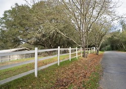 White rail fence along a country lane in Fall or Winter