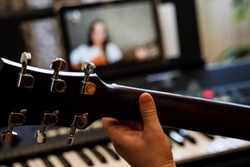 virtual guitar lesson. female musicians play together online in isolation because of the coronavirus pandemic