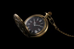 old pocket mechanical watch isolated on black background. fashoinable and antique accessory.