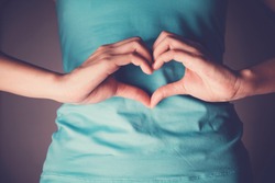 Woman hands making a heart shape on her stomach, healthy bowel degestion, probiotics and prebotics  for gut health, organ donor day