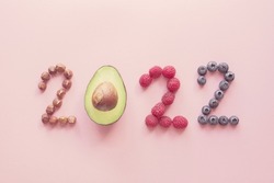 2022 made from healthy food, fruit and nut on pink background, Happy New year, health diet resolution, goals and lifestyle wellbeing