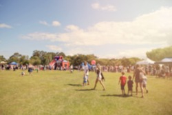 Blur defocused background of people in park fair, summer festival, family outdoors, festive fair