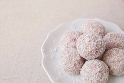 Homemade strawberry, date, cashew and coconut bliss ball on vintage plate