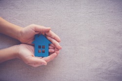hands holding paper house, family home, homeless housing and home protecting insurance concept, international day of families, foster home care, family day care, social distancing