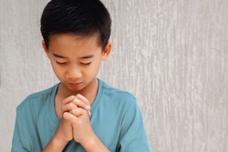 asian boy child praying alone with eyes closed, christianity faith concept, World Day of Prayer,international day of prayer, hope, gratitude, thankful, trust concept