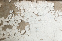 Old background with peeling paint cracks and chips. Light white orange texture