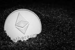 Ethereum coin isolated on black coal background. Ethereum mining. Ethereum closeup. Cryptocurrency mining