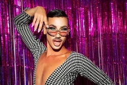 portrait of drag queen diva with fuchsia glitter background