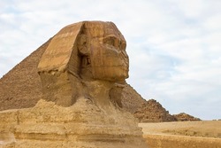 Closeup photo of Sphinx, ancient Egyptian limestone statue of a mythical creature with a lion's body and a human's head. It is located  on the Giza Plateau, the Pyramid Complex near Cairo, Egypt