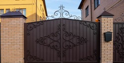 New forged metal double gates for entry of cars into the yard closed