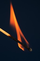 Burning match on a blue background. A wave of yellow flame.
