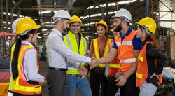 Team of factory workers or technicians celebrate the success together. Collective appreciation and team effort in a factory. Leadership in teamwork