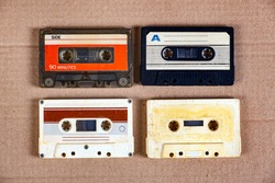 Four Old Audio Cassettes on the Cardboard Background closeup