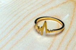 heartbeat ring, symbol of longevity, on wooden background