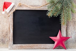 Christmas chalkboard with decoration. Santa hat, stars,  Wooden Background. Vintage Rustic Style.