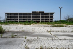 Empty overgrown parking lot and abandoned  former hospital building  Tinley Park Illinois