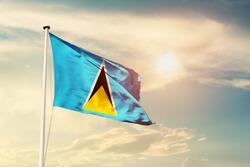 Saint Lucia national flag cloth fabric waving on the sky with beautiful sun light - Image