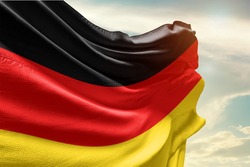 Waving Flag of Germany in Blue Sky. Germany Flag on pole for Independence day. The symbol of the state on wavy cotton fabric.