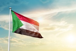 Sudan national flag waving in beautiful clouds.