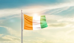 Cote d Ivoire national flag waving in beautiful sky.