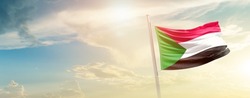 Sudan national flag waving in beautiful sky.