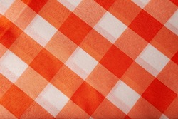 Checkered tablecloth or picnic texture, plaid, clothes. Fabric geometric background, retro textile design. Orange and white plaid.
