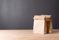 simple brown paper bag for lunch or food on wooden table with copy space