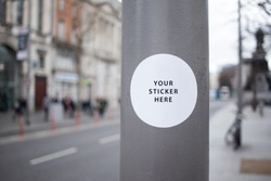 Sticker Mockup on a street lamp in a busy city street