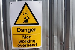 Danger sign fixed to entrance at UK construction site. Warning of men working overhead.