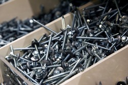 screws with nuts are in a box in a hardware store.  repairs.  close-up .