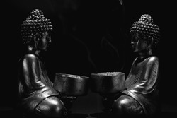 buddha statues face to face black background. space for text