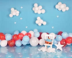photographic background of blue sky with clouds, paper planes and colored balloons