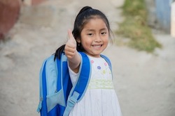 Hispanic girl ready to go to school in rural area - Latin girl on her way to school - Happy Mayan girl with thumbs up