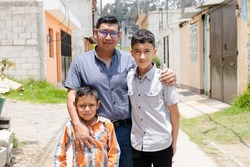 Latin dad with his children outside his house-Hispanic father proud of his children-father of a young family