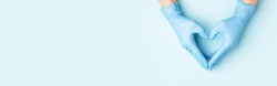 Doctor's hands in medical gloves in shape of heart on blue background. Banner for website with copy space.