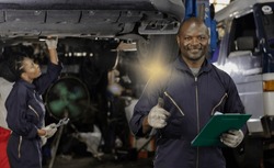 Black car mechanic man and African technician woman working in auto repair service, black mechanic man and woman workers doing car maintenance in garage