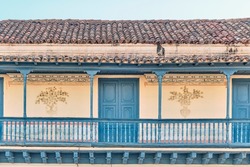 Big balcony with wooden blue railings on second floor of colonial Spanish style house in historic center of Trinidad, Cuba. House of conspirators. Travel, architecture concept