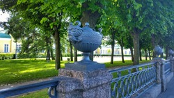 Architectural sculptural forms in the form of mythical animals on a metal and concrete fence. Ancient  fencing in the old garden. Sights and beautiful places in St. Petersburg, Russia.