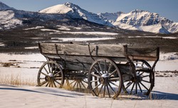A heritage wooden horse drawn wagon on the Alberta prairies by Waterton National Park in the Canadian Rockies.