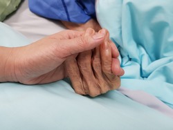 Holding grandmother's hand in the nursing care. Showing all love, empathy, helping and encouragement : healthcare in end of life care and palliative care in hospital concept